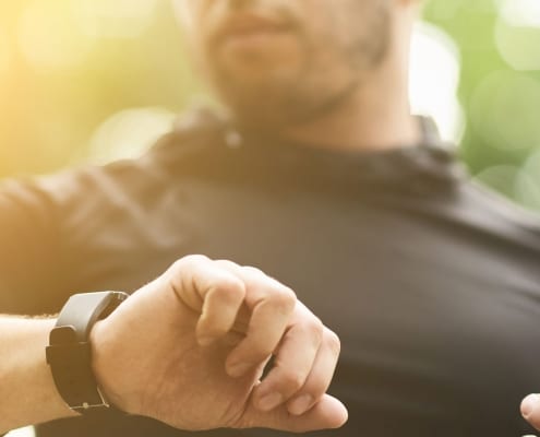 Man looking at smart watch and holding smart phone.