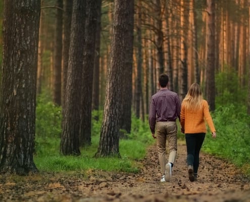Photo of couple walking in woods from Roman Purtov on Unsplash.